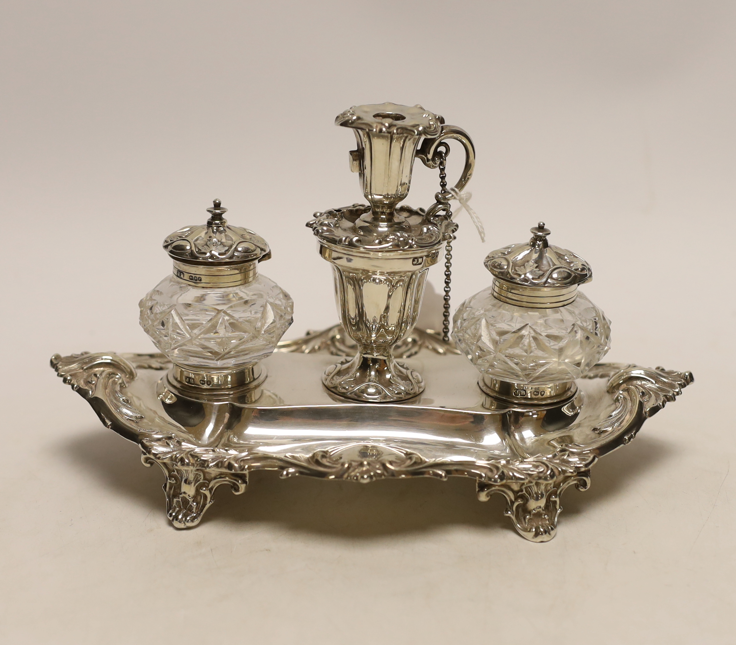 A Victorian silver inkstand, with two mounted glass wells and central removable chamberstick, John Brashier?, London, 1890, 23.4cm, 9.6oz (a.f.).